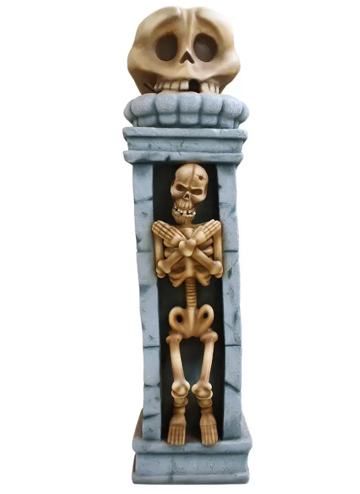 A decorative, spooky pillar features a skeleton trapped inside, with its arms crossed over its chest. A larger, stylized skull sits atop the pillar, completing the macabre design. The background is pure white.