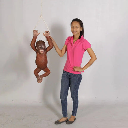 Person holding a small monkey figure against a plain background
