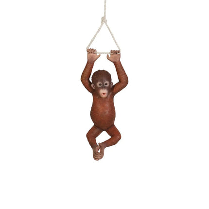 Orangutan figurine hanging from a rope on a white background