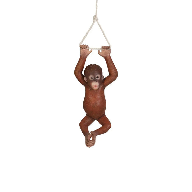Orangutan figurine hanging from a rope on a white background