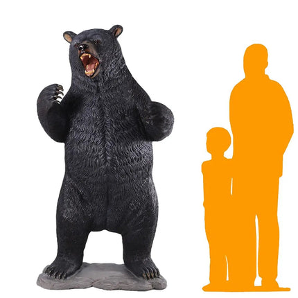 Black bear figurine next to orange silhouette figures on a white background