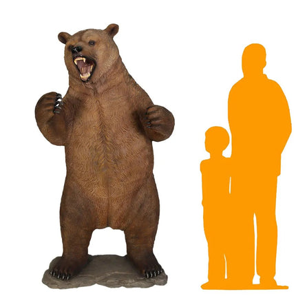 Life-size bear statue with orange silhouette figures of a man and child on a white background