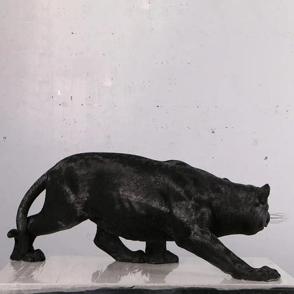 Black panther statue on a white surface with a light gray background