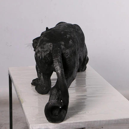 Black panther figurine on a white surface with a light gray background