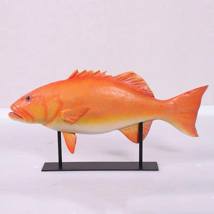 Orange fish model on a stand against a white background
