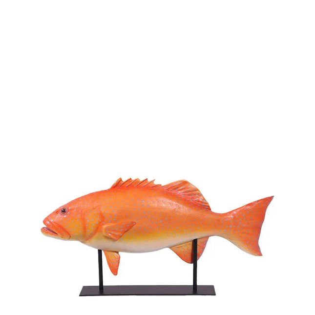 Orange fish model on a stand against a white background