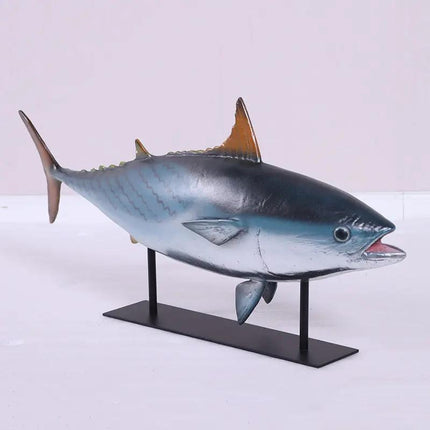 Model of a tuna fish on a stand against a white background