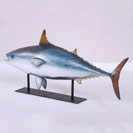 Model of a tuna fish on a stand against a white background