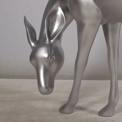 Metallic silver deer sculpture on a neutral background